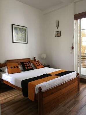 Relax in this serene bedroom with a comfortable bed, large window, and framed artwork.
