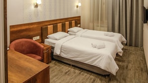 A hotel room with two beds, a wooden desk, and a red chair. - Hotel Lider Complex (Vayk)