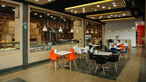 A modern cafe with wooden accents, a variety of seating options, and a visible counter with food displays. - Hotel Lider Complex (Vayk)