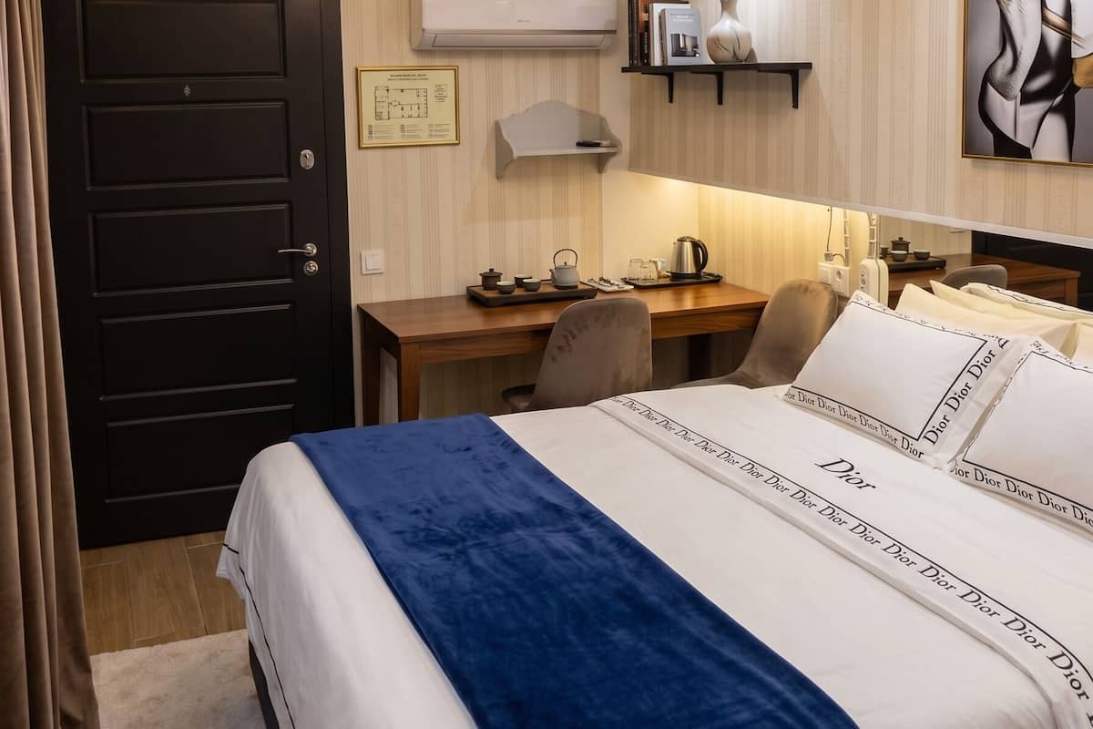 Ein Hotelzimmer mit Bett, Schreibtisch, Stuhl und Deckenleuchte.
