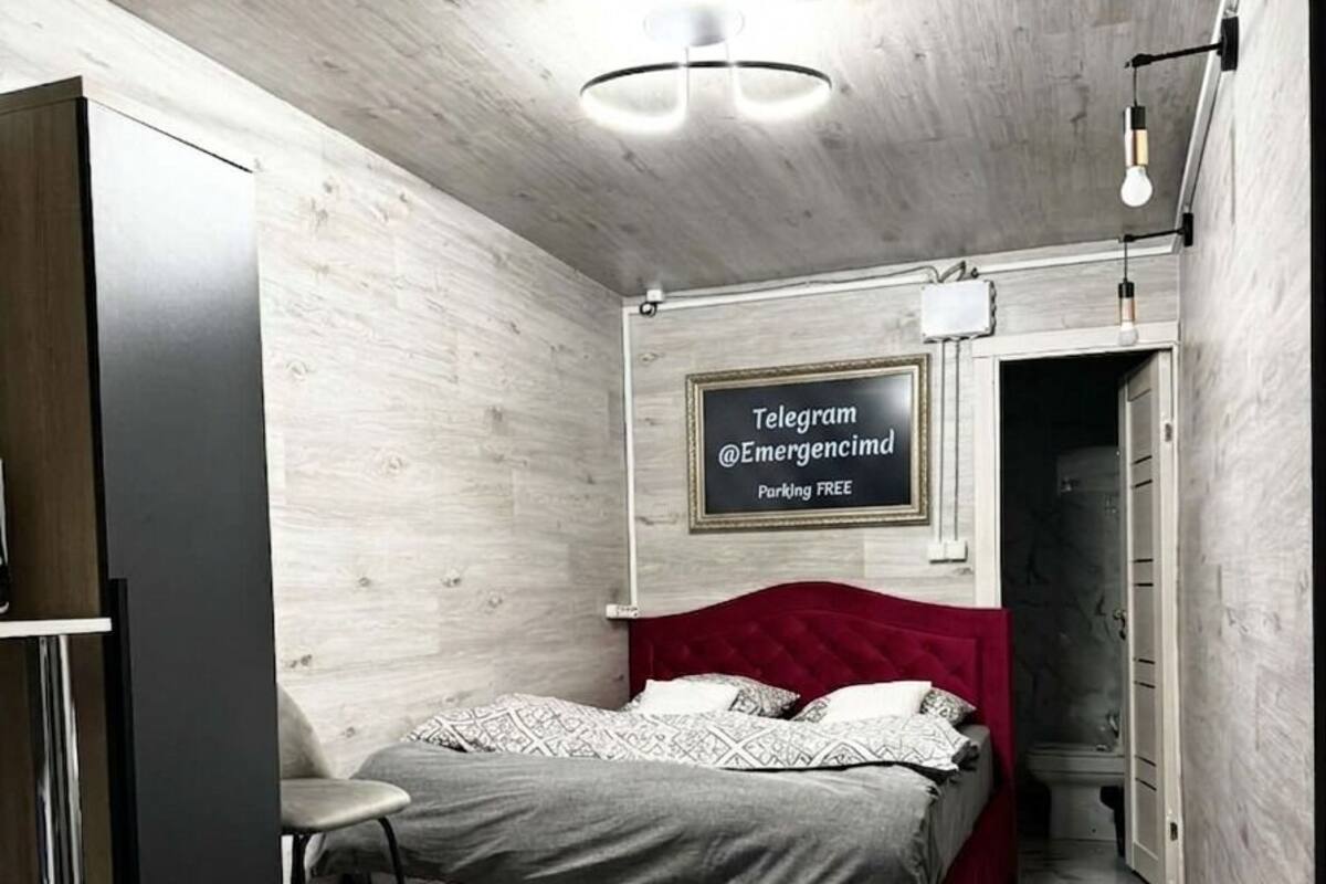 Ein Schlafzimmer mit einem Bett, einem Schreibtisch, einem Kleiderschrank und einem Schild an der Wand.