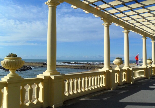 A coastal promenade with a series of white columns and balustrades, overlooking the sea and rocky shoreline. - Harbour Inn Design Townhouse (Matosinhos)