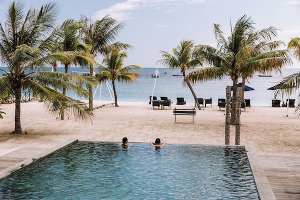 Una piscina al aire libre, sombrillas, tumbonas