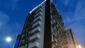Een modern hotelgebouw met een 7-Eleven winkel op de begane grond.