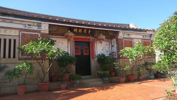 A traditional building with a tiled entrance and potted plants. - Shuitou Inn I (Jincheng)