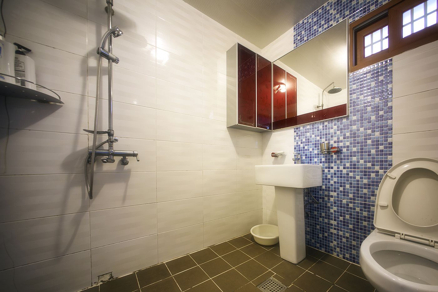 Ein Badezimmer mit Dusche, Toilette, Waschbecken und Fliesen.