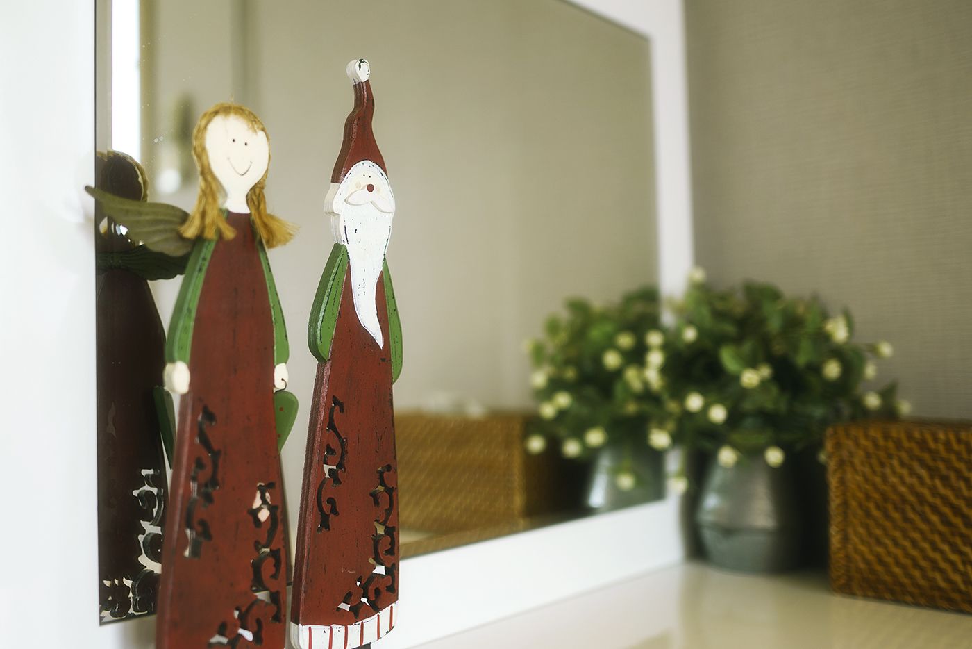 A decorative figure with a green hat and a white beard, standing next to a figure with a green dress and wings.