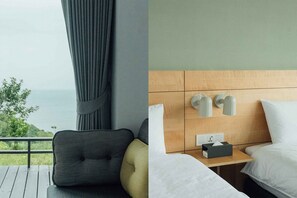 A hotel room with a view of the sea, a wooden headboard, a bedside table with a lamp, and a bed with white linens. - Day Spring (Nangan)