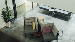 Un área de estar exterior moderna con un sofá, una mesita redonda y un banco.