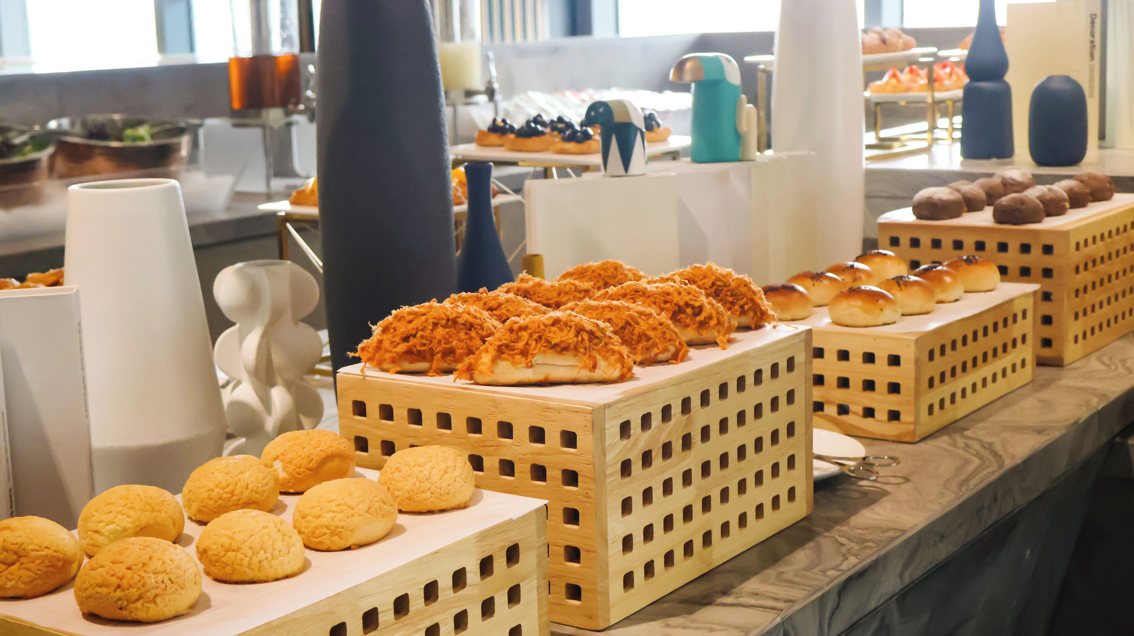 A buffet with various baked goods including bread and pastries.