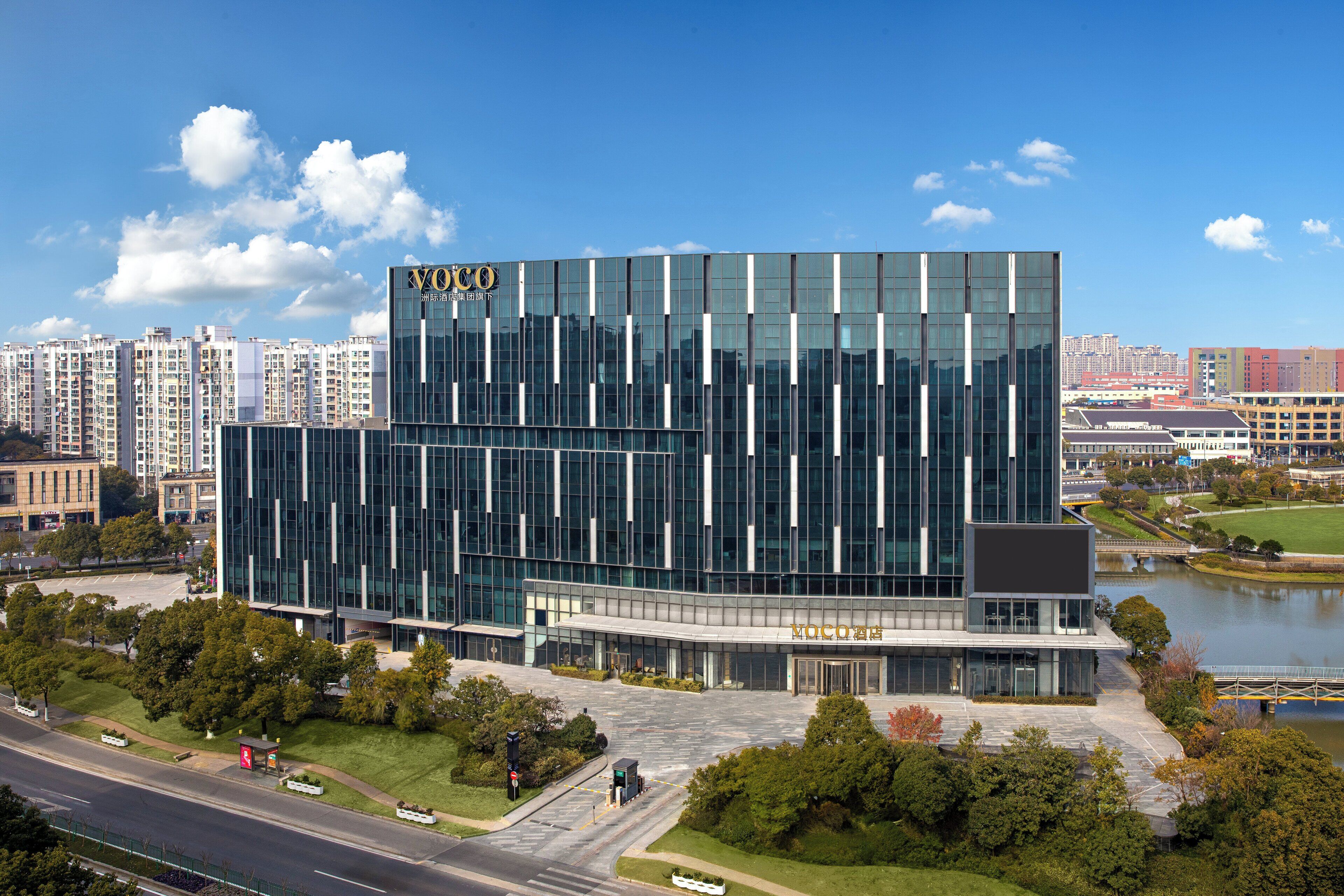 A modern building with a glass facade and a sign that reads "Voco".