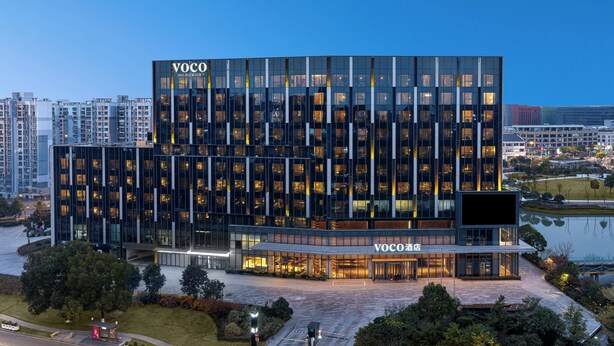 Un edificio moderno con fachada de vidrio y un letrero que dice "VOCO".