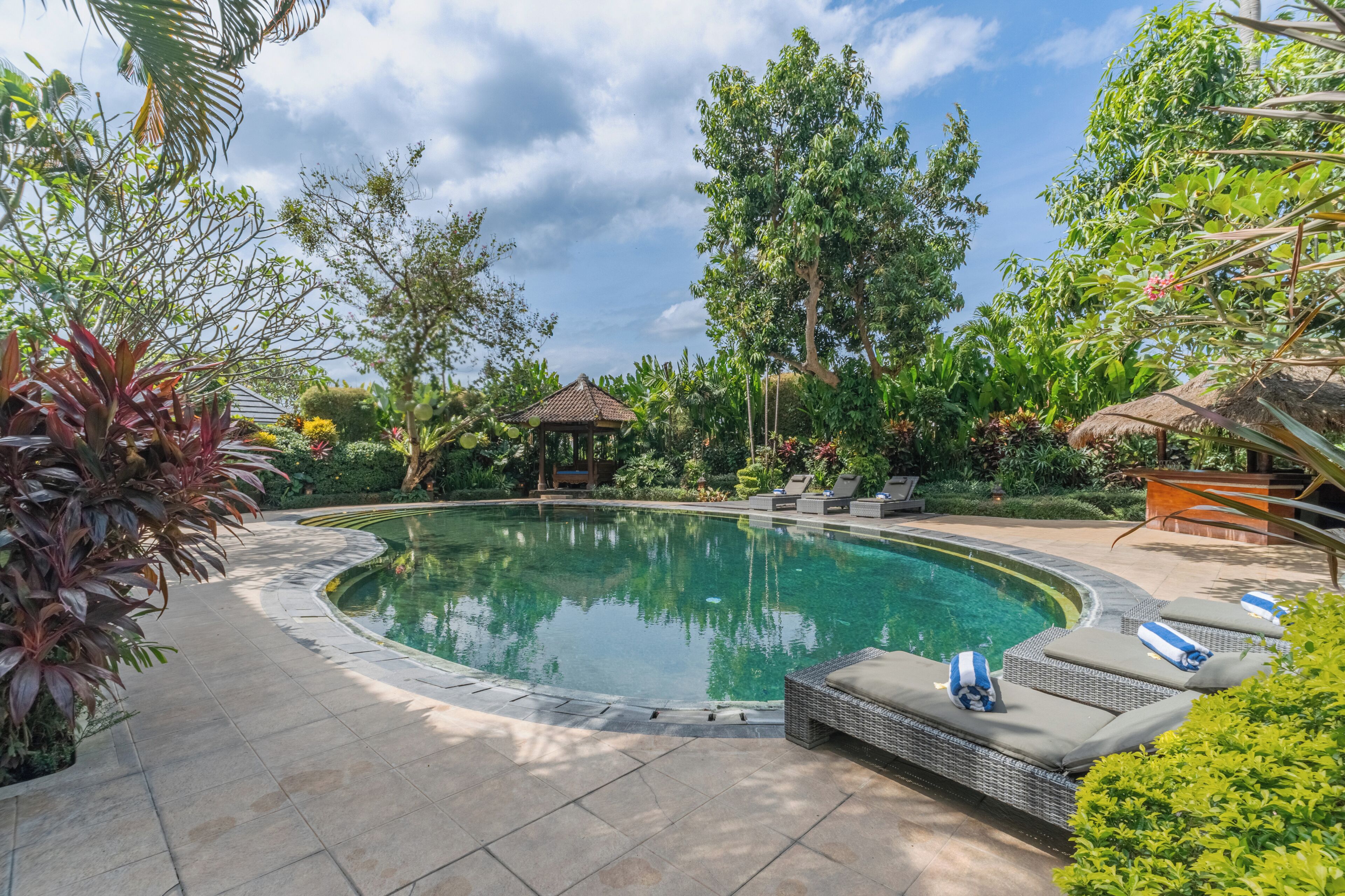 Una piscina al aire libre, sillones reclinables de piscina