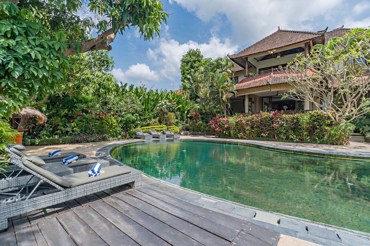 A pool area with lounge chairs and a wooden deck.