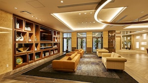 A modern lobby with a central seating area, built-in shelving, and a large window. - Welina Hotel Premier Nakanoshima EAST (Osaka)