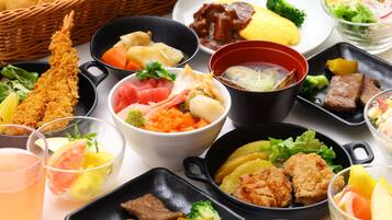A variety of dishes including sushi, sashimi, and tempura, arranged on a table.