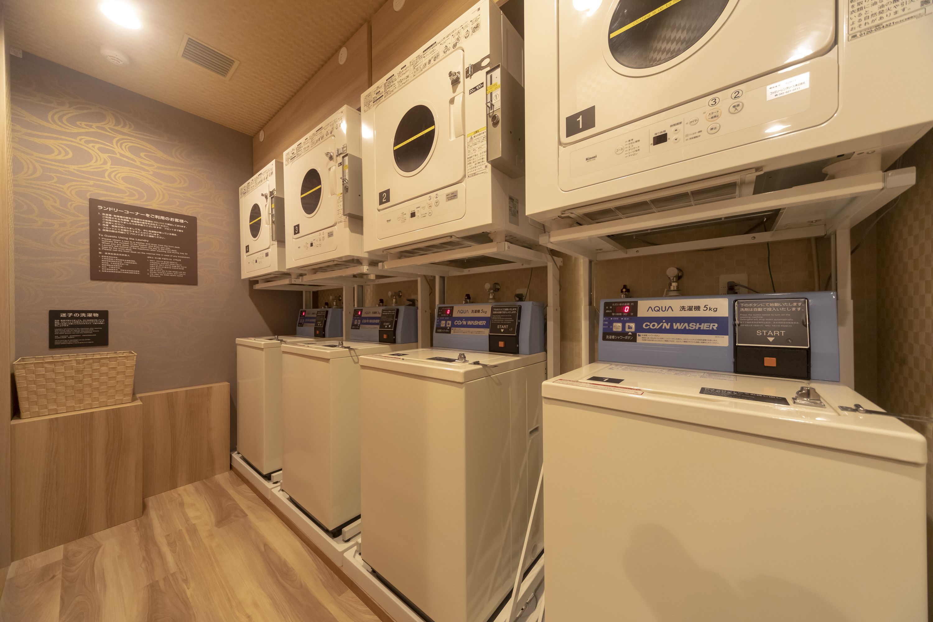 A laundry facility with multiple washing machines and dryers, including a CO/N WASHER.