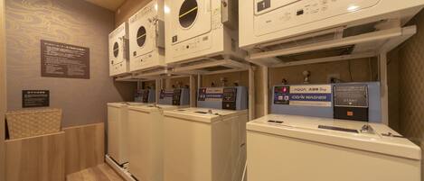 A laundry facility with multiple washing machines and dryers, including a CO/N WASHER.