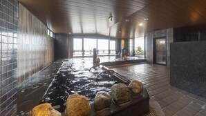 A spa area with a hot tub, wooden ceiling, tiled walls, and large windows. - Dormy Inn Kawasaki Natural Hot Spring (Kawasaki)