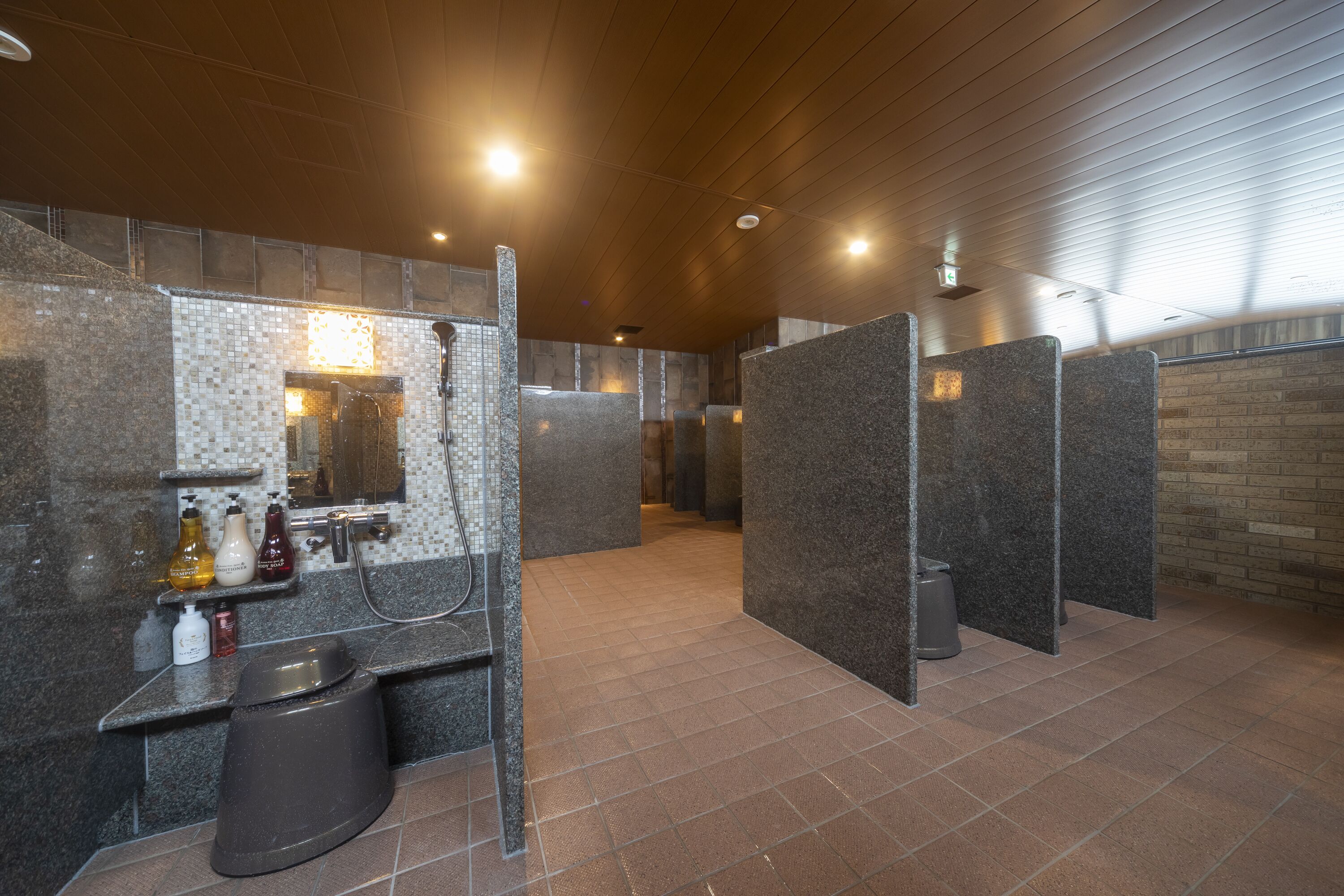 A modern bathroom with granite countertops, a shower area, and a tiled floor.