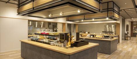 A modern kitchen with a central island, built-in appliances, and a brick backsplash.