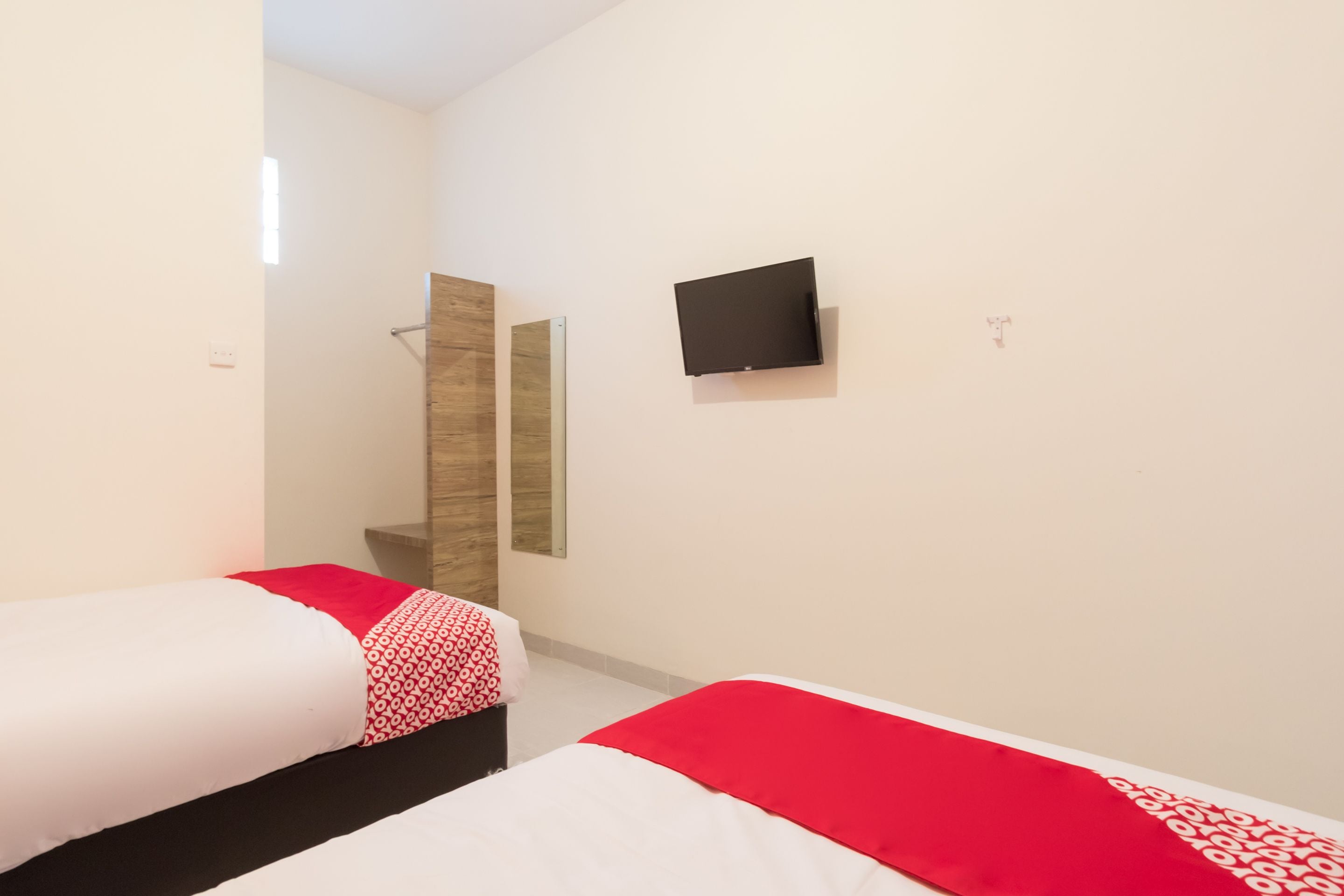 Une chambre d’hôtel avec deux lits, une télévision et un espace douche.
