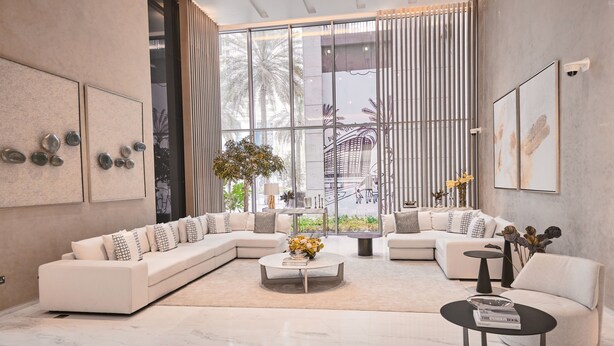 A modern living room with a sectional sofa, a coffee table, and a small side table. - Fantastay Blvd Crescent (Dubai)