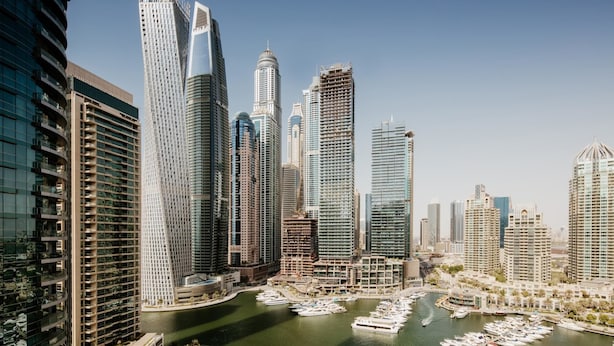 A cityscape with high-rise buildings and a marina with boats. - Fantastay Marina Tower (Dubai)