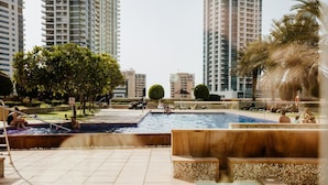 A rooftop pool area with tiled flooring, a hot tub, and a small pool. - Fantastay Marina Tower (Dubai)