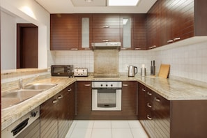 Equipped with an oven, microwave, and toaster, this kitchen offers a convenient cooking space with a sink and window above the stove.