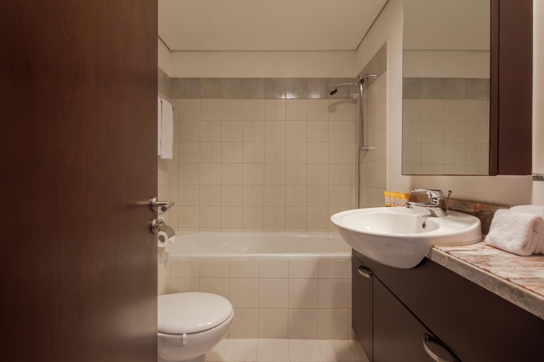 A bathroom with a toilet, bathtub, and sink.