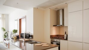 A modern kitchen with a central island, stainless steel appliances, and a minimalist design. - Fantastay Marina Gate Tower (Dubai)
