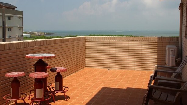 Un balcón con vista al mar, que incluye una mesa y sillas.