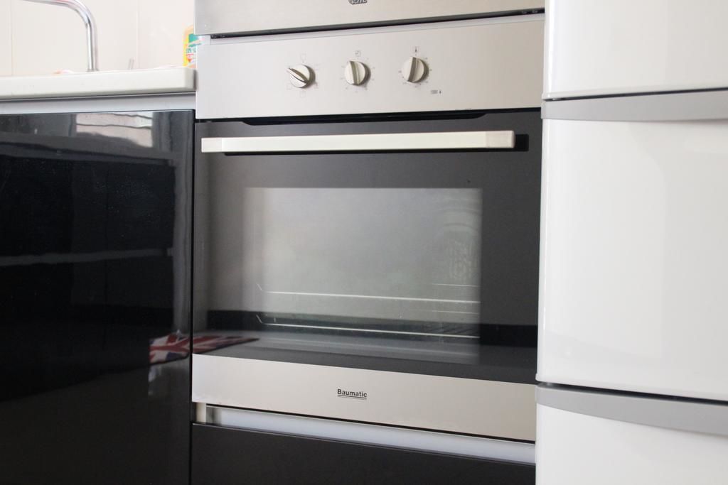 Cozinha moderna com forno embutido e micro-ondas.