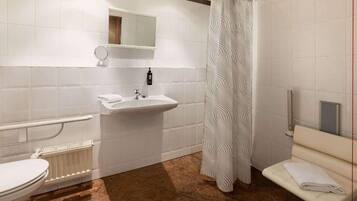 A bathroom with a toilet, sink, and shower curtain.