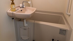 A bathroom with a sink, mirror, shower, and three soap dispensers. - Fukuoka Haneul inn (Fukuoka)