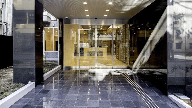 A modern hotel entrance with a glass door, a tiled floor, and a ceiling with recessed lighting. - Hotel Lantana Naha matsuyama (Naha)
