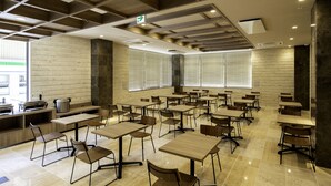 A modern classroom with wooden tables and chairs, large windows, and a tiled floor. - Hotel Lantana Naha matsuyama (Naha)