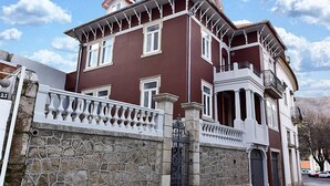 A two-story building with a stone facade, multiple windows, and a balcony. - Casa com Historia (Covilhã)