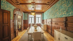 A traditional dining room with wooden paneling, a long table, and chairs. - Casa com Historia (Covilhã)