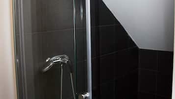Ducha con mampara de vidrio, tragaluz, azulejos negros y ducha.