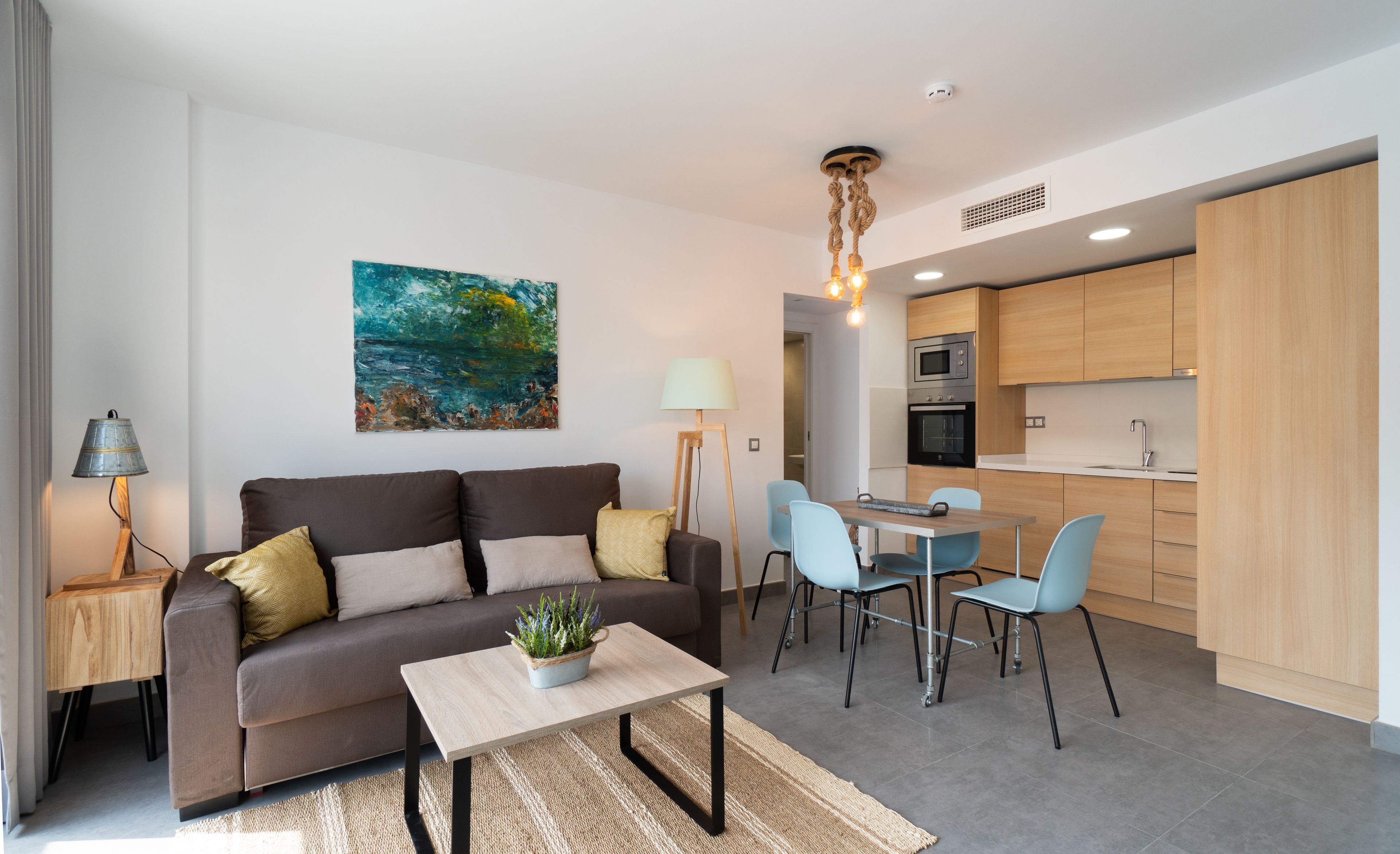 Un salon moderne avec un canapé, une table basse et un tableau accroché au mur.