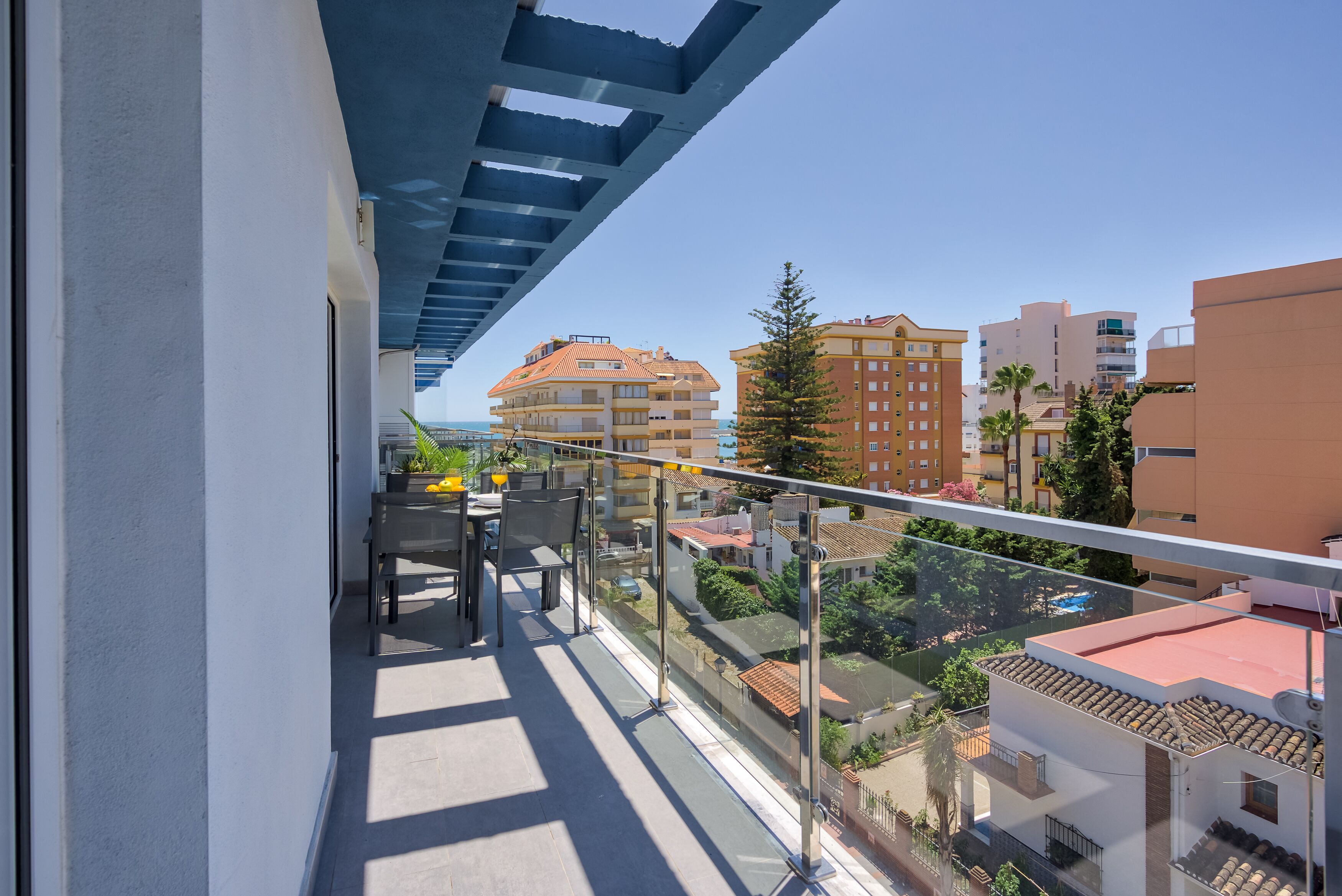 Un balcón con vistas despejadas de los edificios circundantes y una masa de agua distante.
