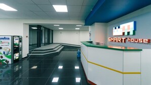A reception area with a 'SMART house' sign, a coffee machine, and a water dispenser.