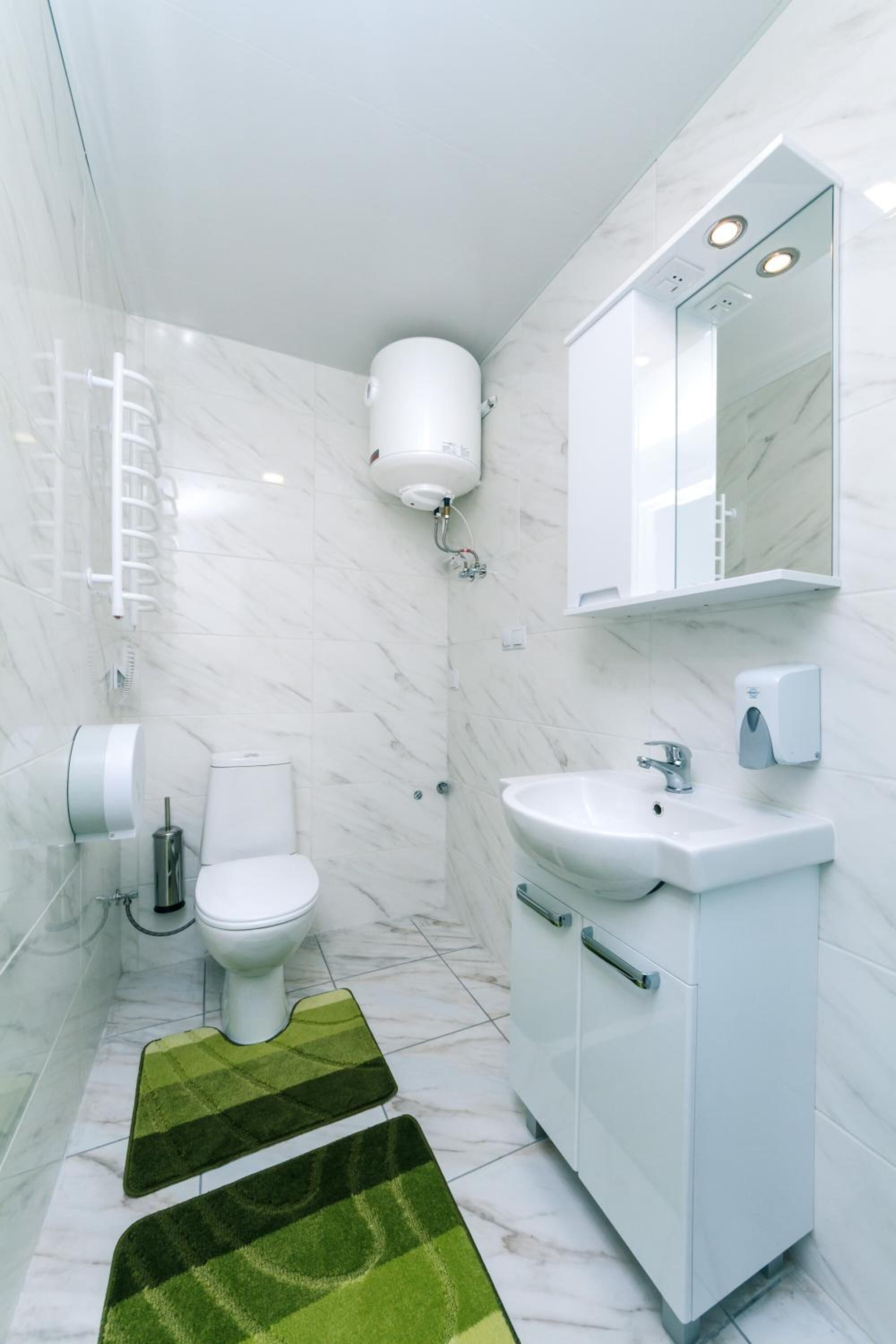 Een moderne badkamer met toilet, wastafel en spiegel.