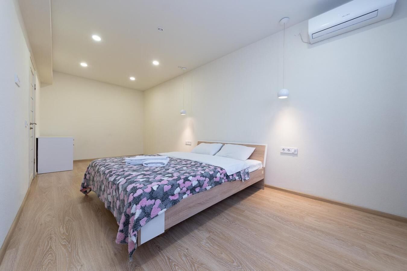 Un dormitorio con cama, armario y aire acondicionado.