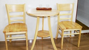 A small wooden table with two chairs, a tray with glasses, and a white wall. - Saigon City Center - Hostel (Ho Chi Minh City)