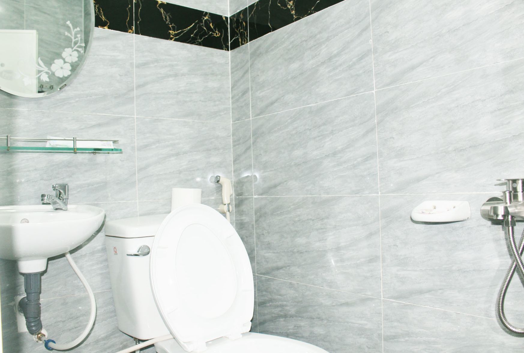 A bathroom with a toilet, sink, and shower.