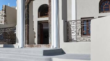 Um edifício com uma entrada imponente, com colunas brancas e telhado de telhas vermelhas.