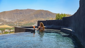 Una persona en una piscina con un paisaje montañoso al fondo.